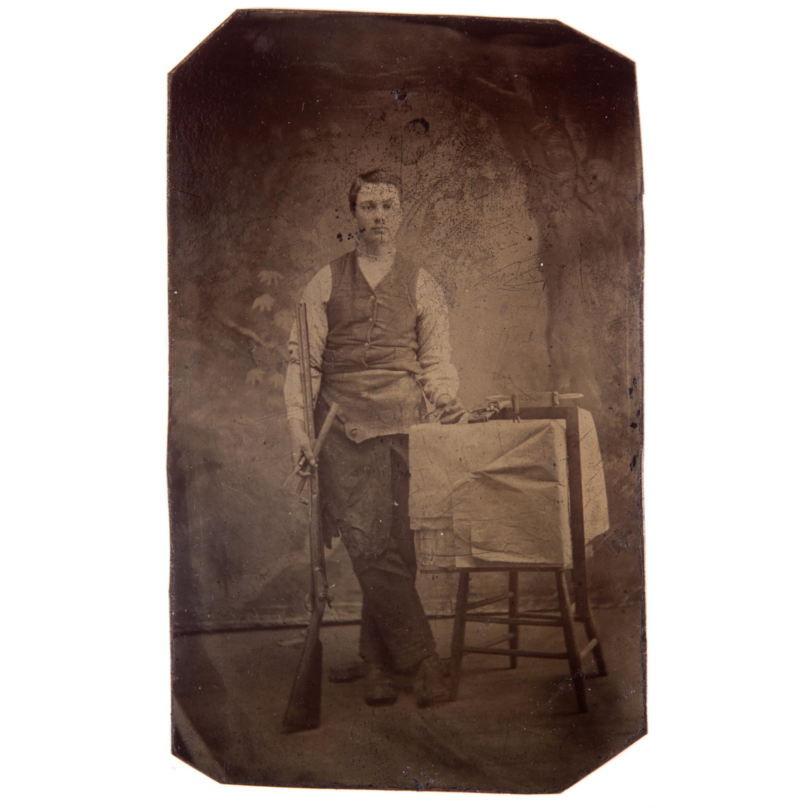 OCCUPATIONAL TINTYPE GUNSMITH: 6th plate; image of young man standing with long gun and tools; no case; no mat; G-VG
