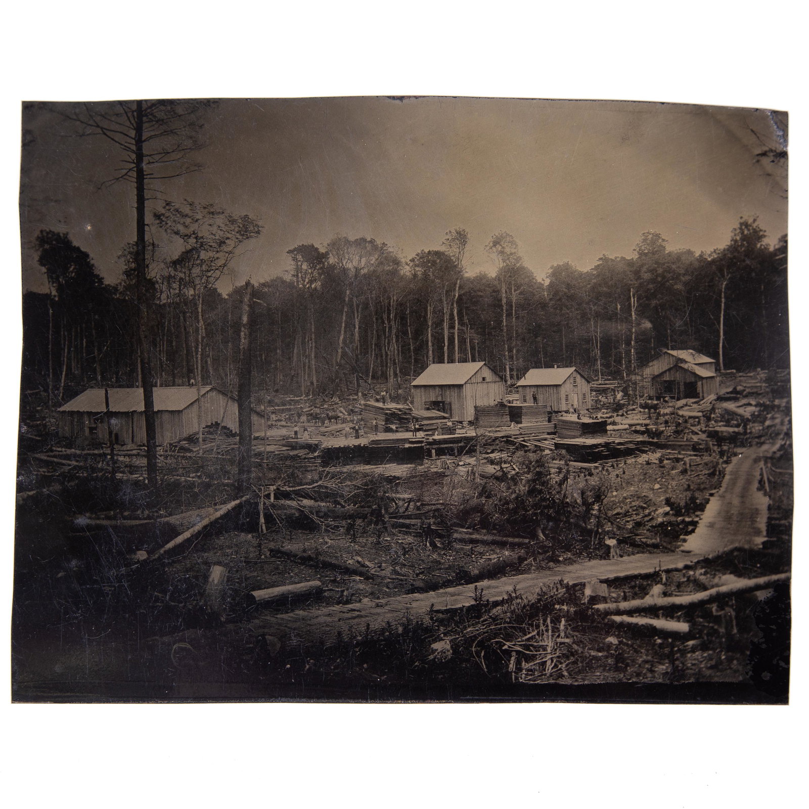 LUMBERYARD TINTYPE: Cut-down full plate; image of large lumber mill and yard with numerous workers and horses; no case; no mat; minor scratches; light crazing; 5 3/4" x 7 1/4", G-VG