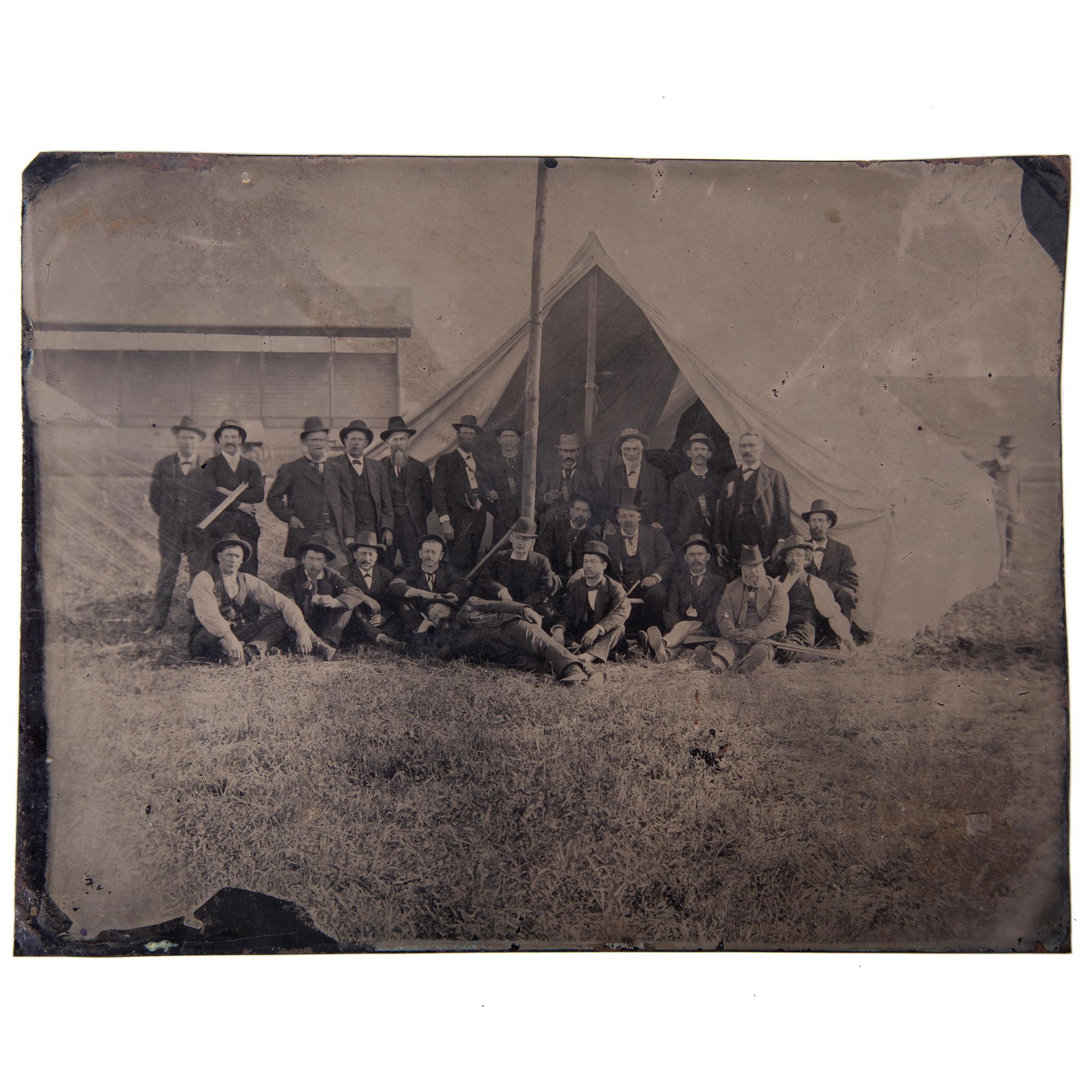 TINTYPE REUNION (?) GROUP: Full plate; (24) men standing and seated, three with long guns, all in front of large tent; no case; no mat; normal wear; G-VG