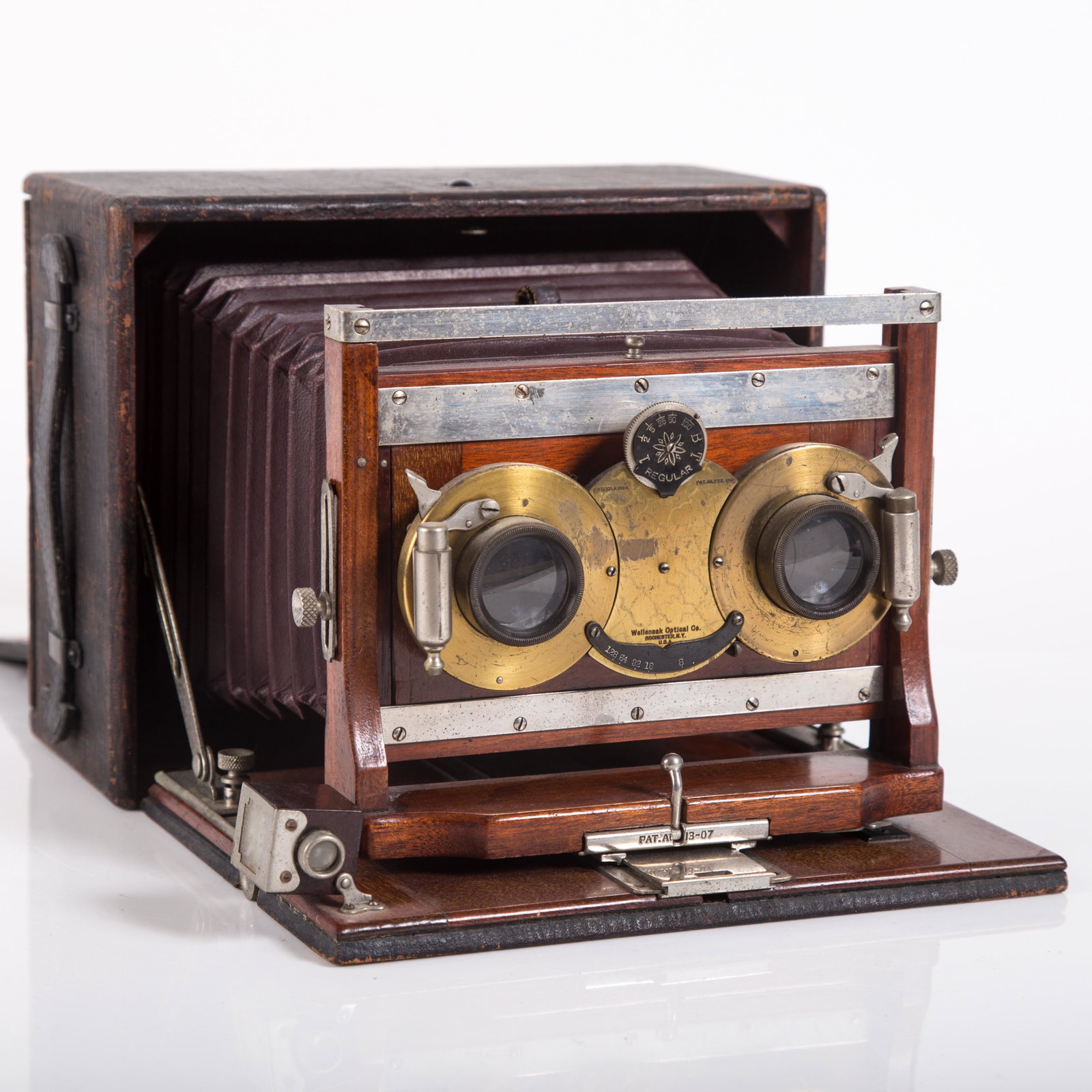 CONLEY STEREO CAMERA: Maroon bellows; mahogany and leather cover; Wollensak shutter; normal wear; some light pitting; H-6 1/2", G-VG