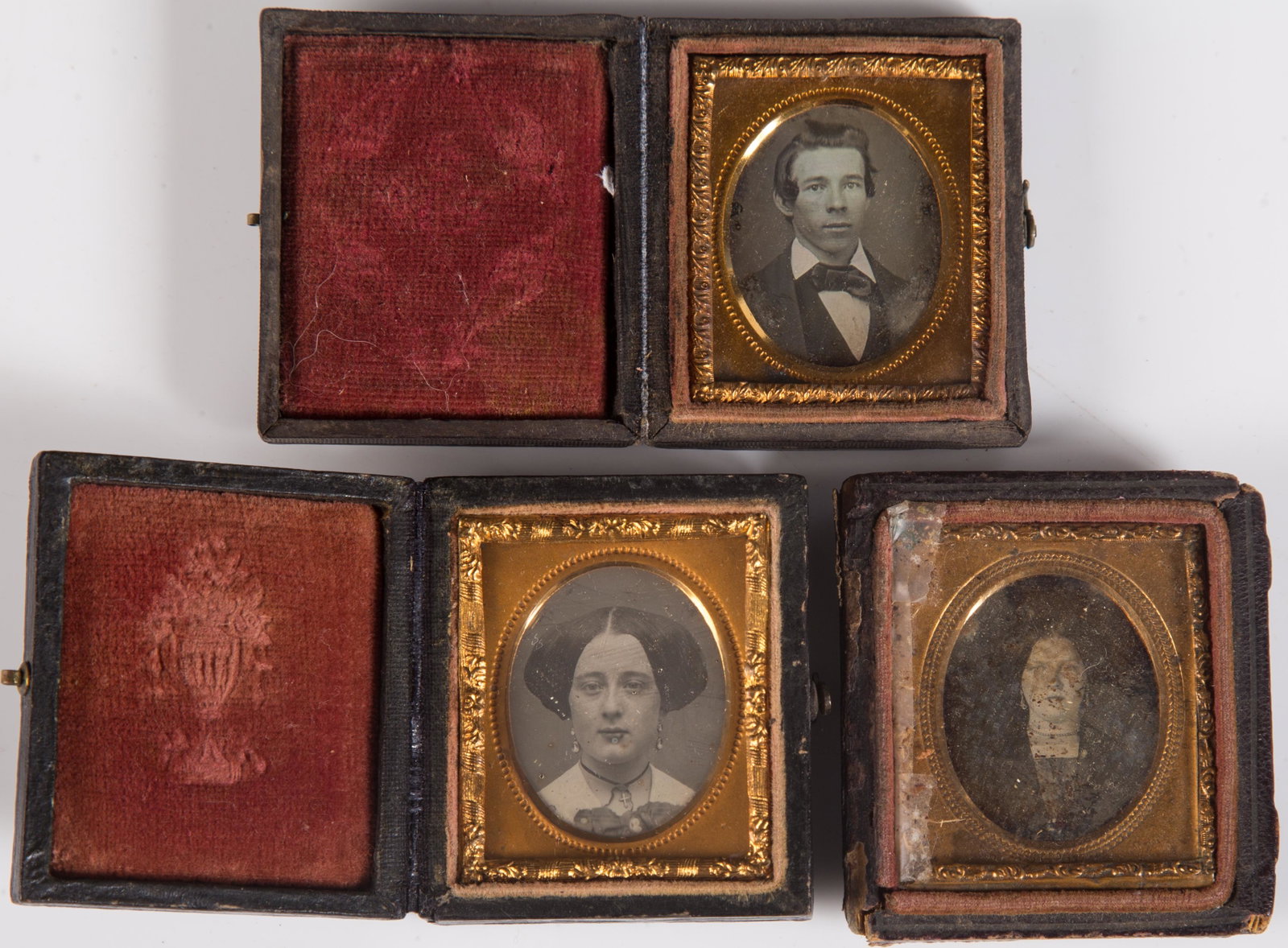 MINIATURE DAGUERREOTYPE PORTRAIT IMAGES (3): 6th plates or smaller; (2) of women, (1) young gentleman; gilt metal mats; stamped cases; (1) missing half; (1) needs cleaning; cases 2" x 1 3/4", F-VG