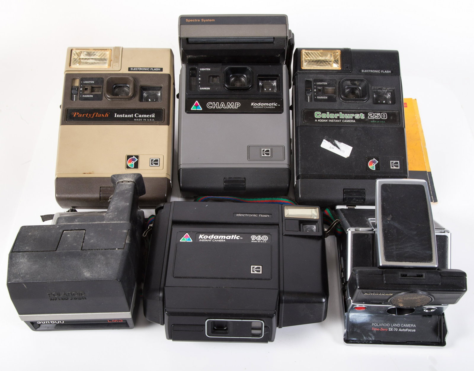 KODAK & POLAROID CAMERAS (7): (1) Kodak "Colorburst 250" with pamphlet; (1) Kodamatic "Champ" instant camera; (1) Kodamatic "960" instant camera; (1) Kodak "Party Flash" instant camera; (1) Polaroid "SX-70"; (1) Polaroid Spectra S
