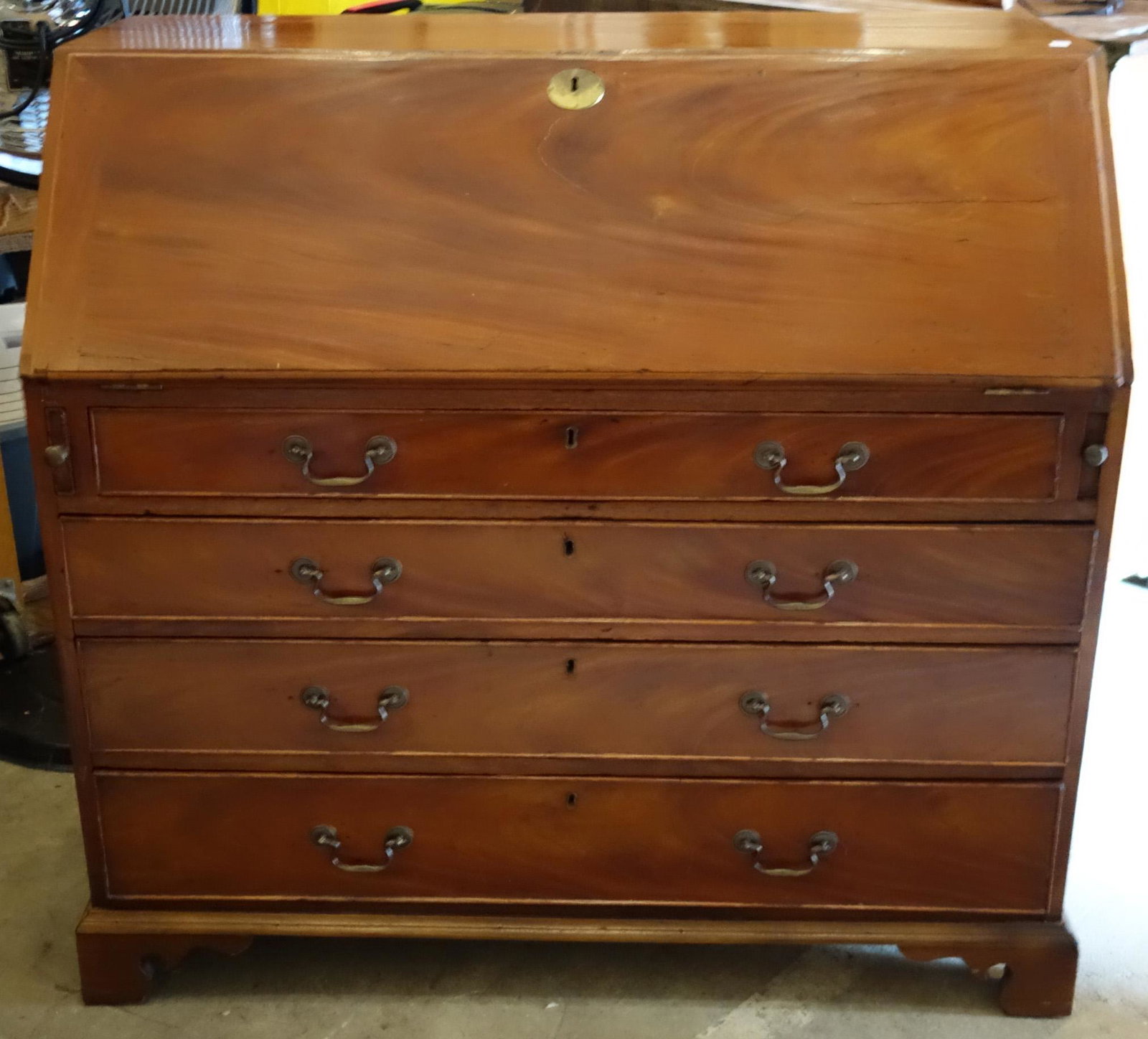 CHIPPENDALE SLANT FRONT DESK: English; mahogany; four graduated drawers; bracket feet; simple well with leather inset surface and simple inlay; slight check on lid; normal wear; H-44", W-46", G-VG