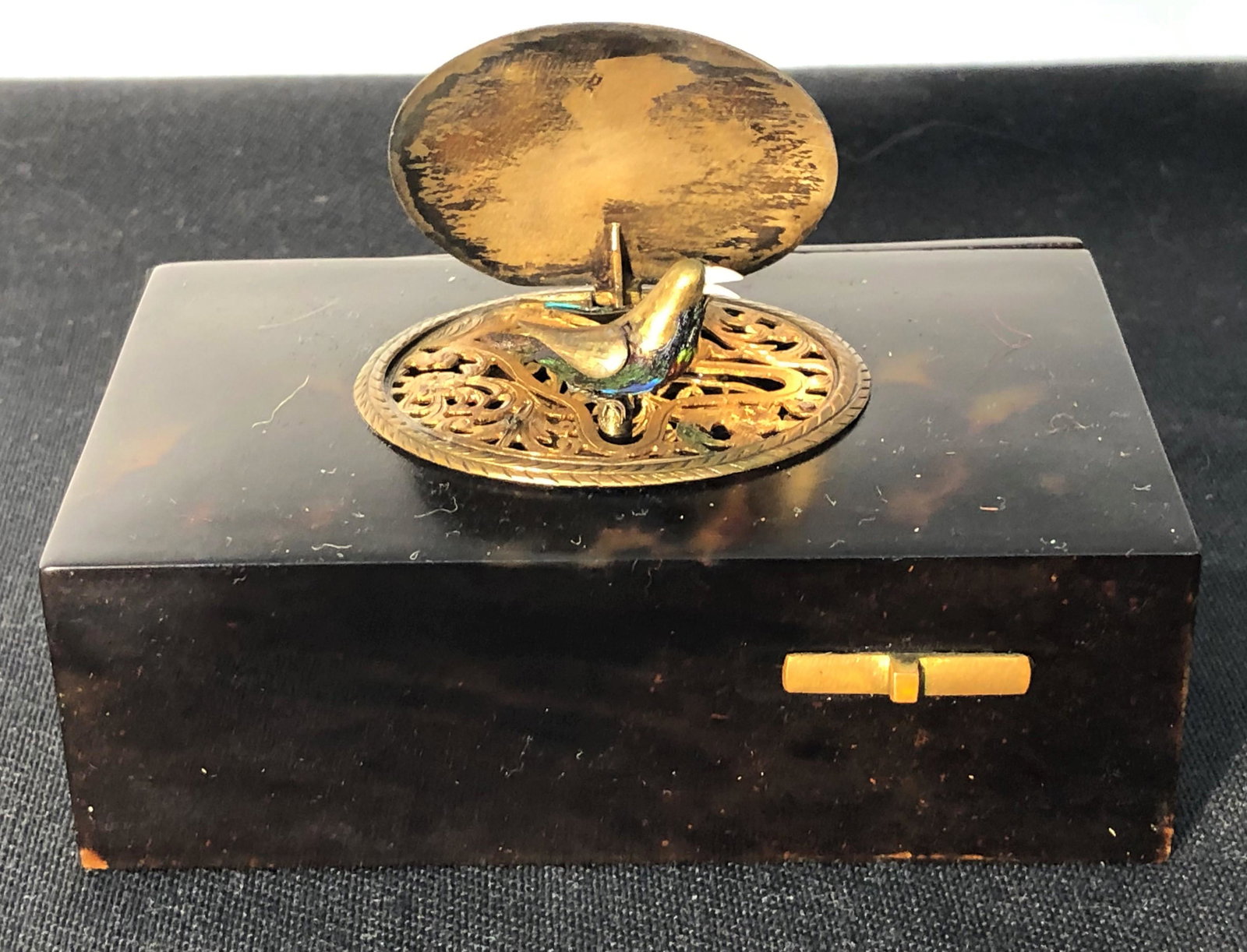 BIRD MUSIC BOX: Mechanical; silver pop up; oval top engraved with birds; working, but bellows whistling mechanism needs work; interior needs cleaning; (1) feather wing missing; H-1 1/4", L-3 3/4", G