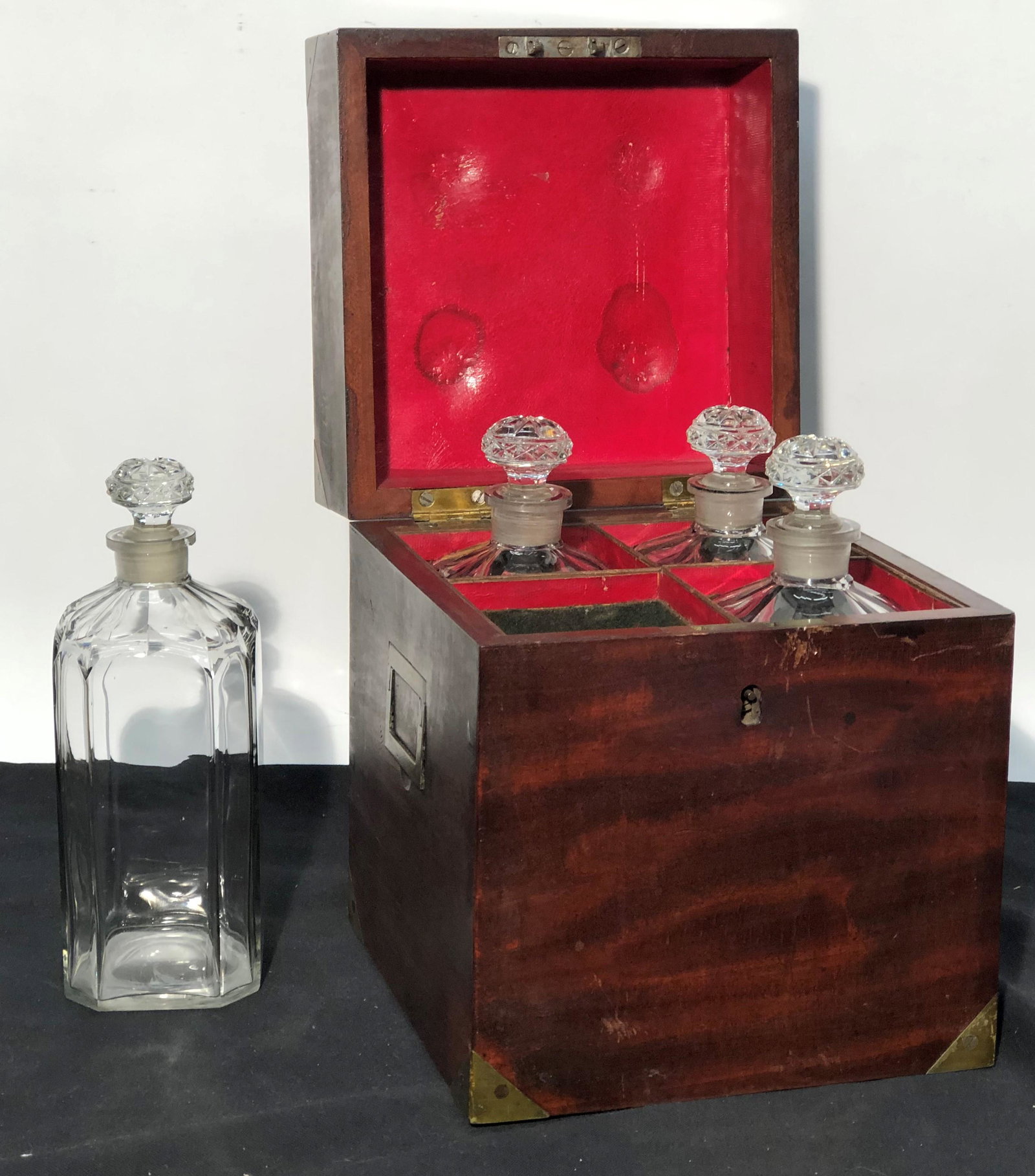 ANTIQUE CELLARETTE: Mahogany case with brass handles and corners; (4) crystal bottle interior; case wear and case has small piece of wood loss on top; (2) bottles have slight rim chips; H-10 1/2", G