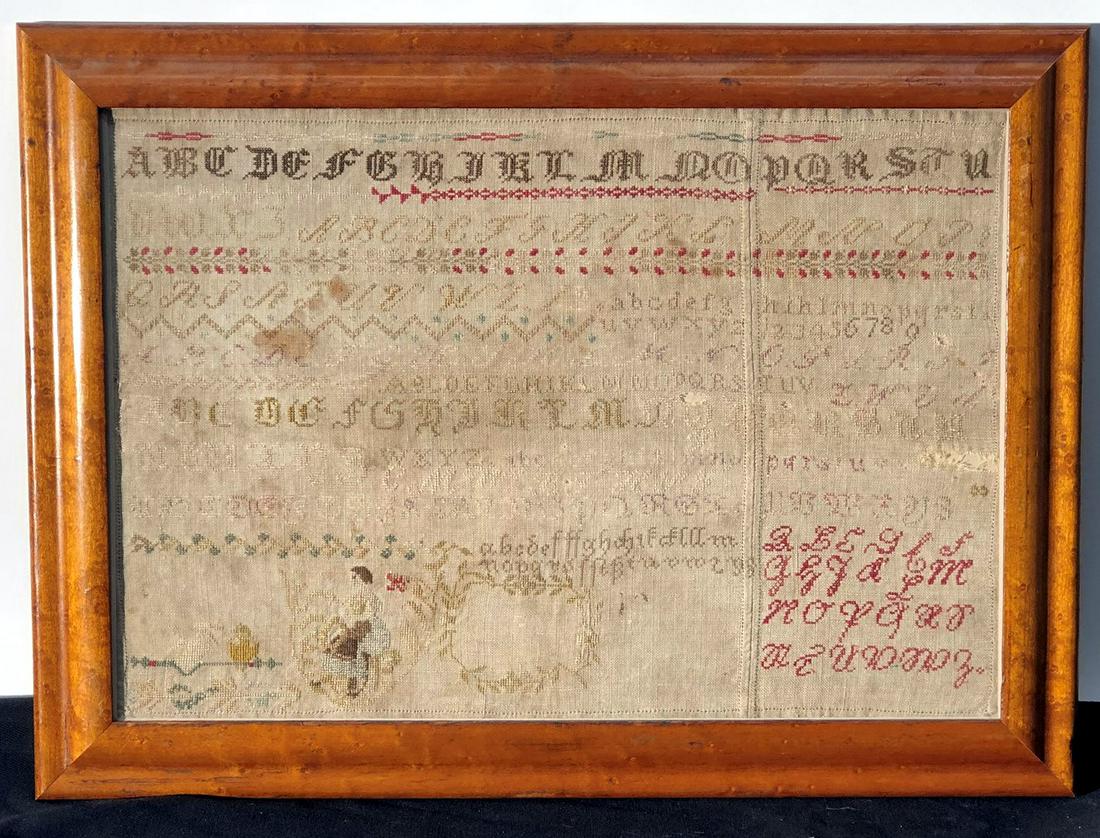 SAMPLER: Alphabet, lady, bird, wreath; fabric pieced together; framed; (4) small holes, small stains; 11" x 6", F