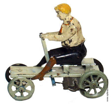 GERMAN HANDPAINTED TIN BOY ON VELOCIPEDE: GERMAN TIN BOY ON VELOCIPEDE - Hand painted, mechanical, working, some surface rust on wheels, some paint flaking, L-5", G-G+