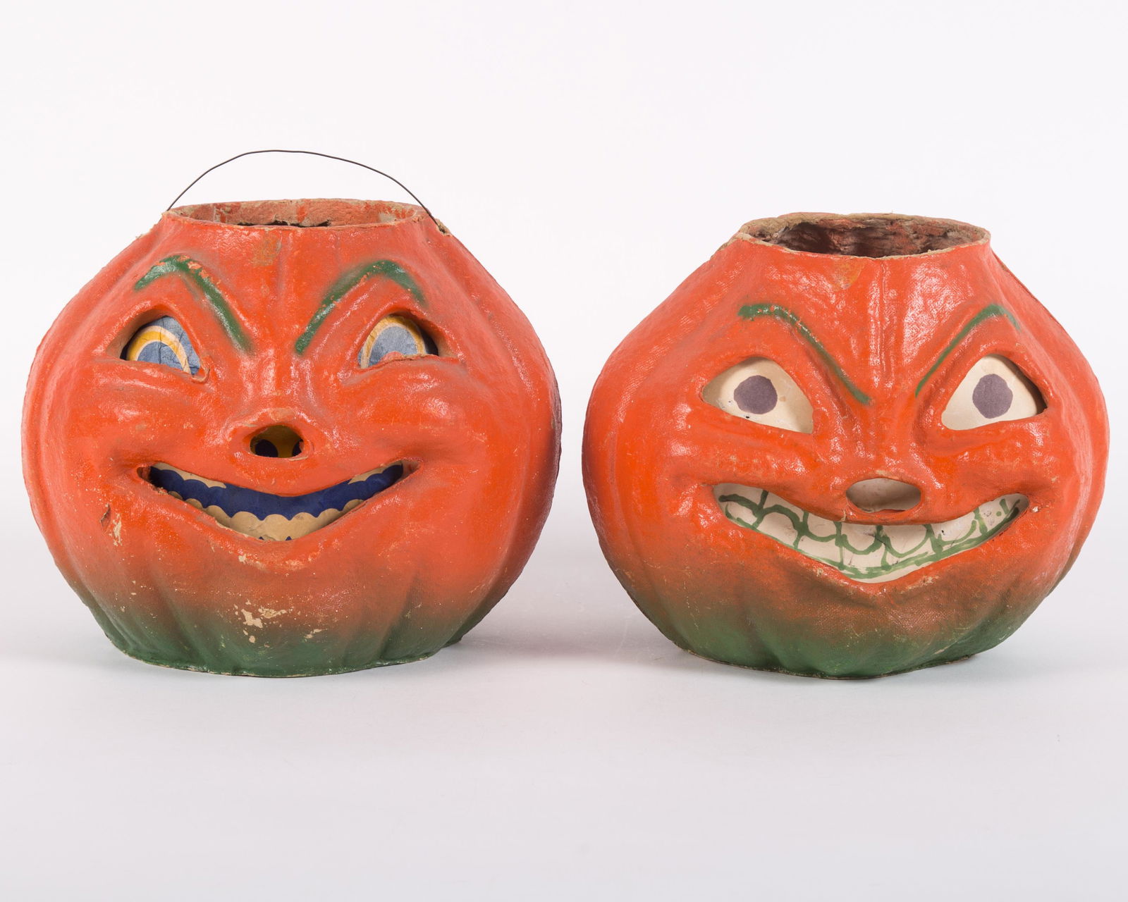 VINTAGE PAPIER MACHE JACK O'LANTERNS (2): Painted egg carton material; (1) printed paper insert, minor paint loss overall; has wire handle; (1) paper insert has been hand colored with markers; minor paint loss; tear on nose and top left at ha