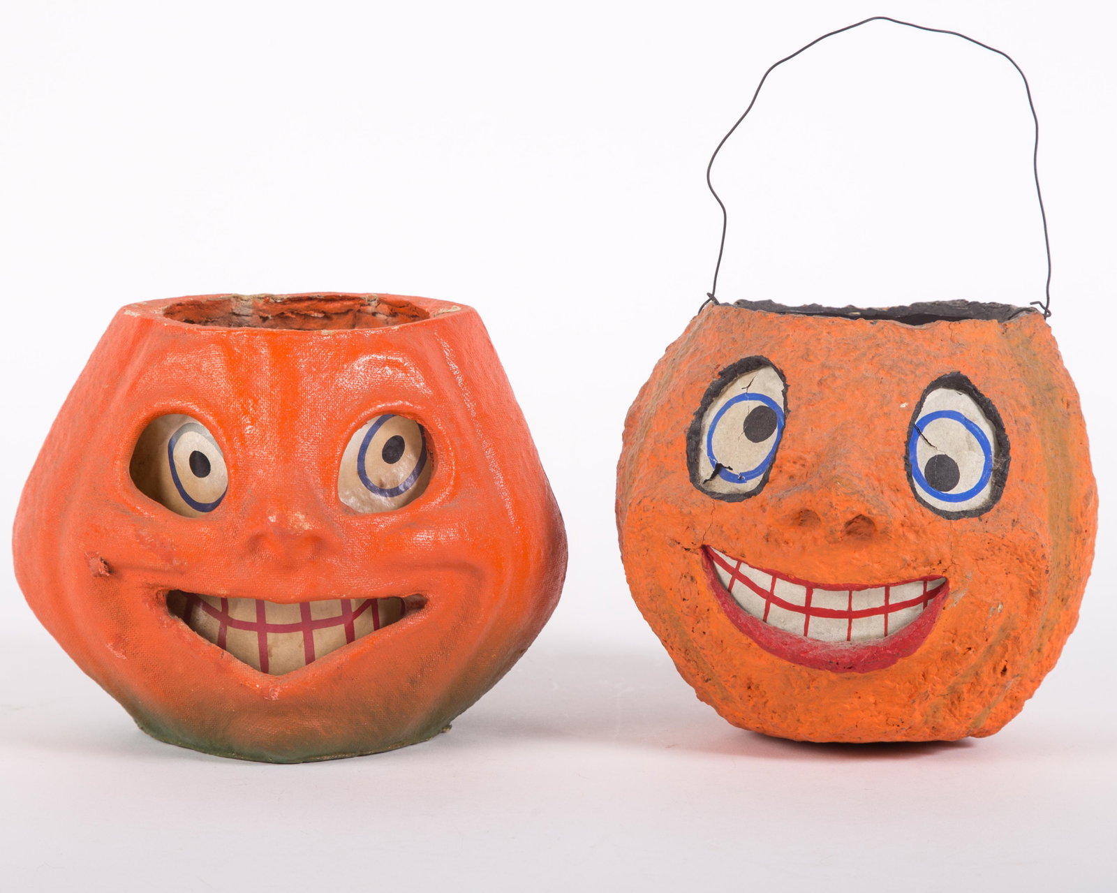 VINTAGE PAPIER MACHE JACK O'LANTERNS (2): Painted egg carton with printed & painted paper inserts; (1) painted insert, retains wire handle; paper in eye holes have tears; (1) printed paper insert, minor spotting, no wire handle; minimal paint