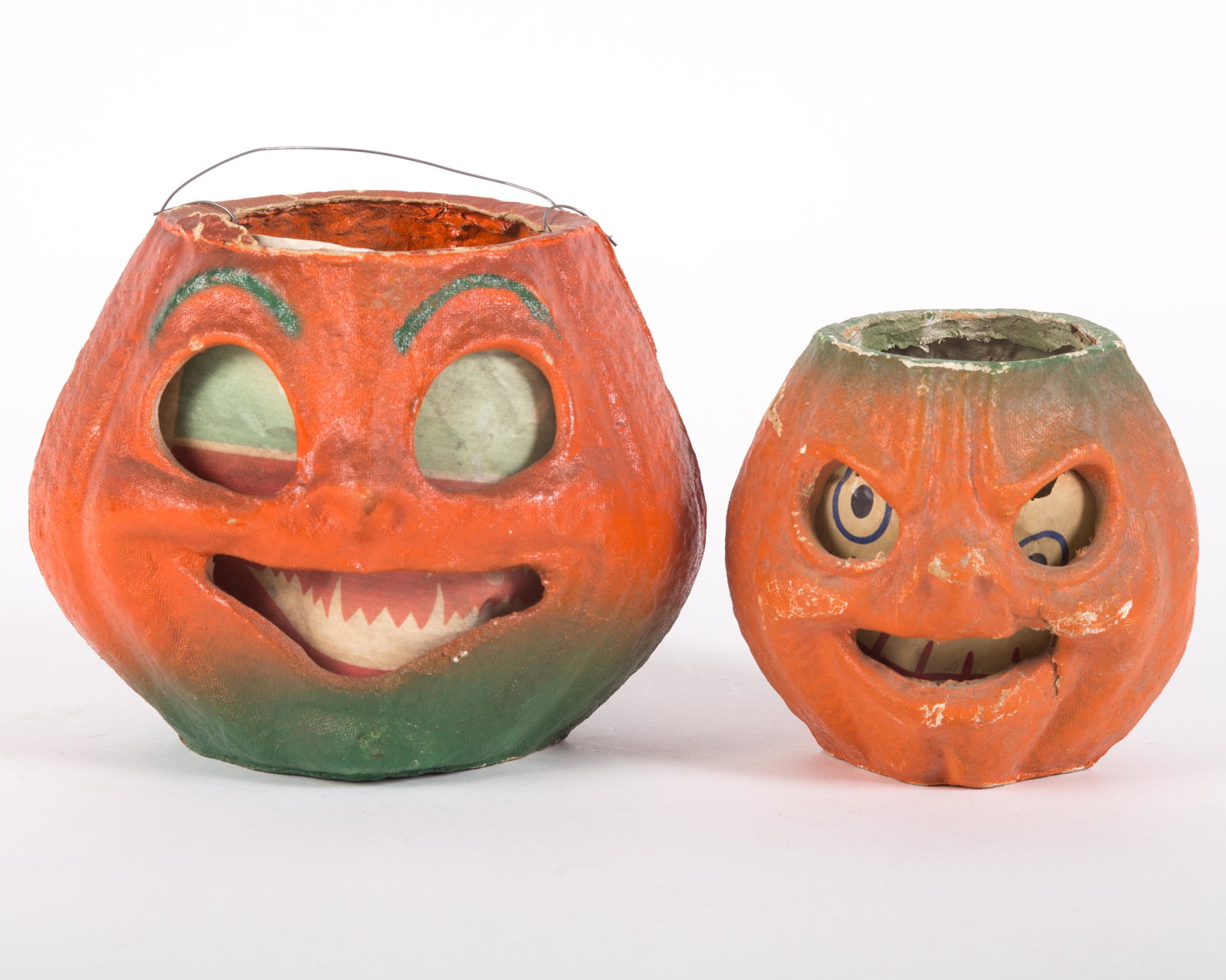 VINTAGE PAPIER MACHE JACK O'LANTERNS (2): Painted egg carton; printed inserts; (1) large Jack o'Lantern has replaced paper insert; minor paint loss; wire handle; (1) small Jack o'Lantern paper insert hash edge tears and some small holes; over