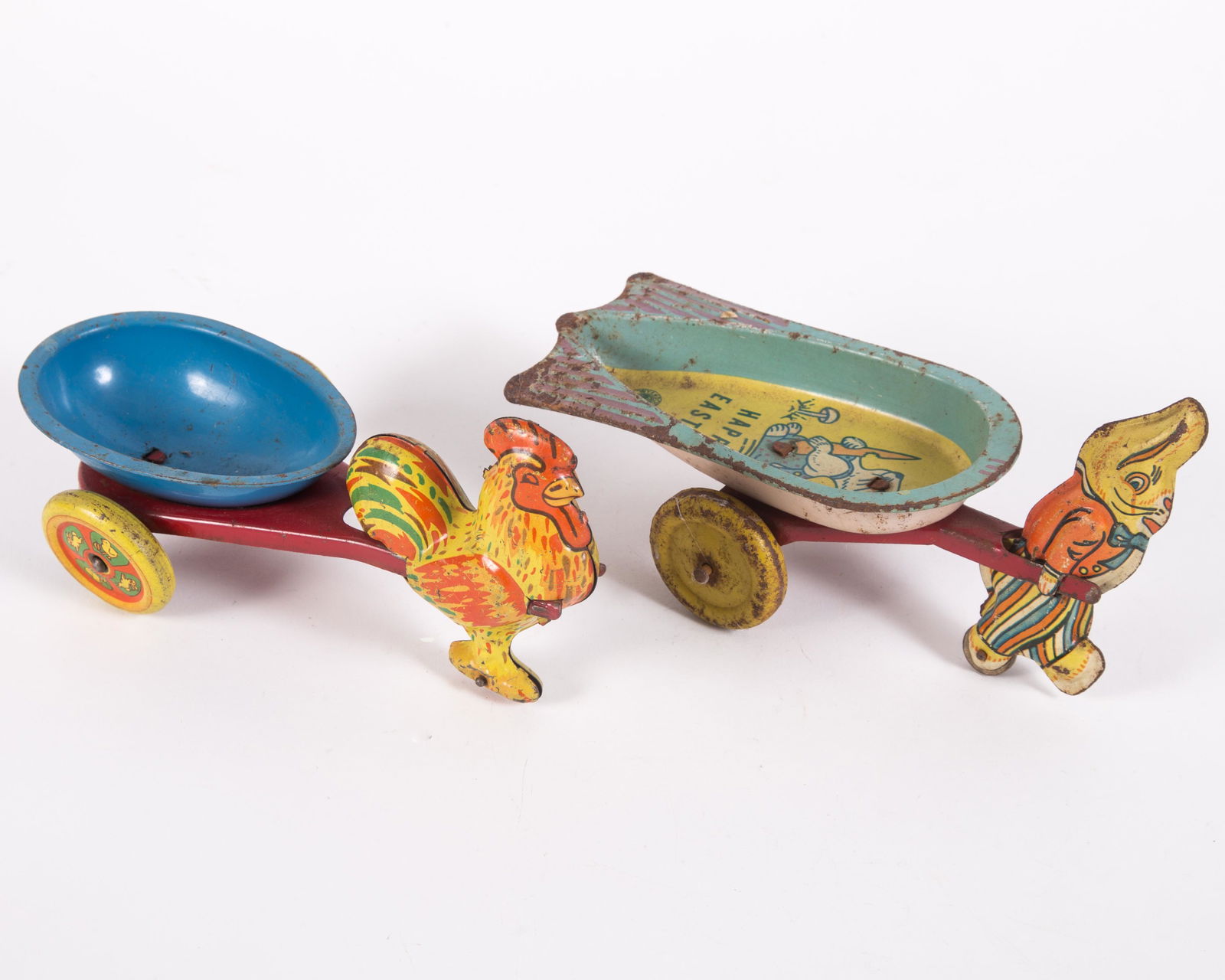 WYANDOTTE EASTER CANDY TOYS (2): (1) Rooster pulling egg-shaped cart; (1) rabbit pulling "Happy Easter" cart; "Happy Easter" cart is rusting had slightly bent; some scratches and fading; L-8", G-VG