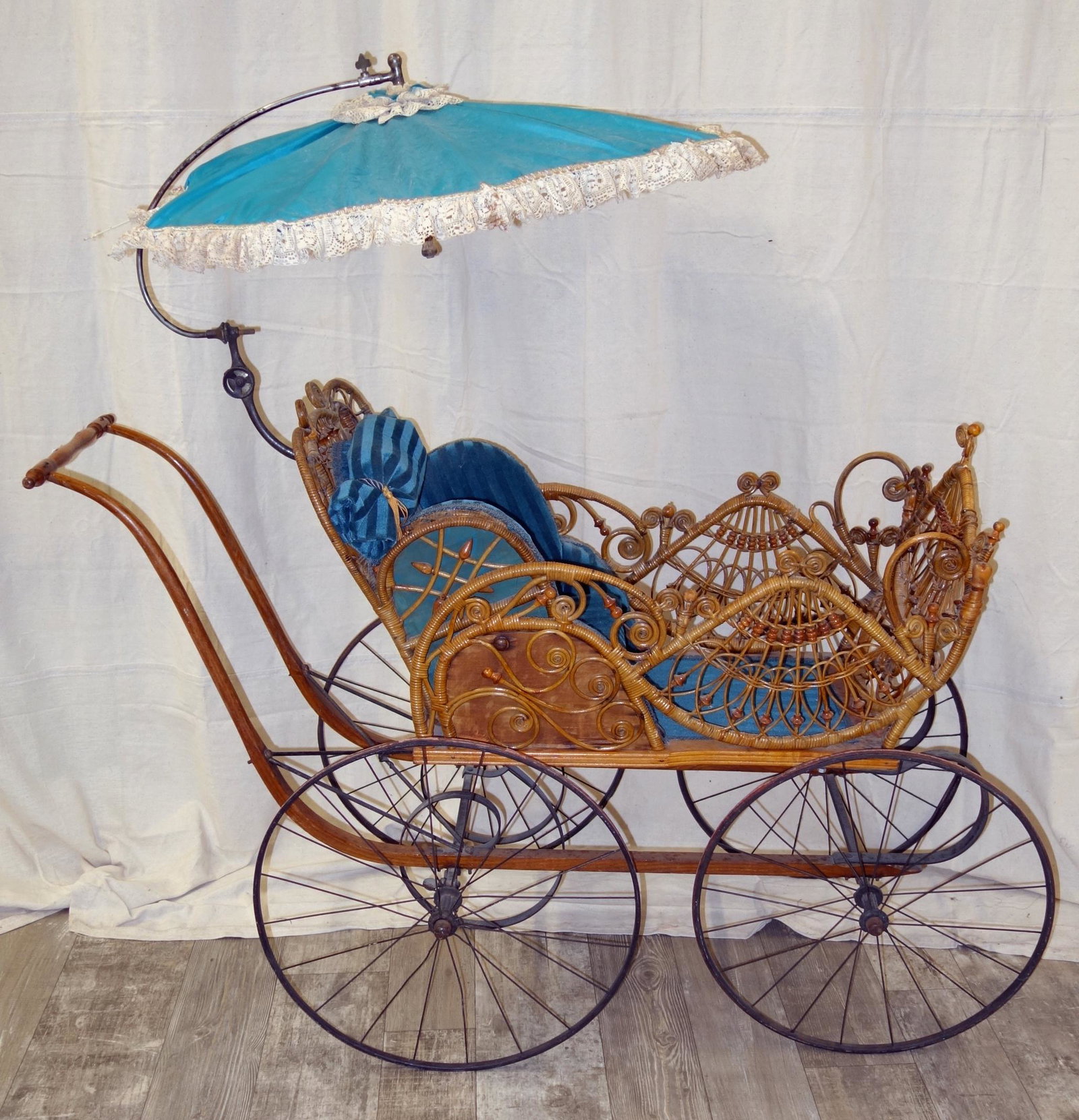 VICTORIAN WICKER STROLLER: Umbrella hinge loose and fabric has pulled away from support wires; wood handle slightly bent; some minor unravelling; one wicker scroll has probably repair; L-57", G-VG