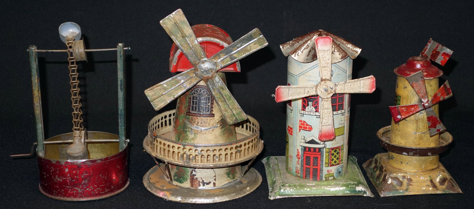 LOT OF (4) TIN TOYS: (3) tin litho windmill toys, (1) mechanical well toy; chips and wear in paint and decoration; some rust; H-7", P-F