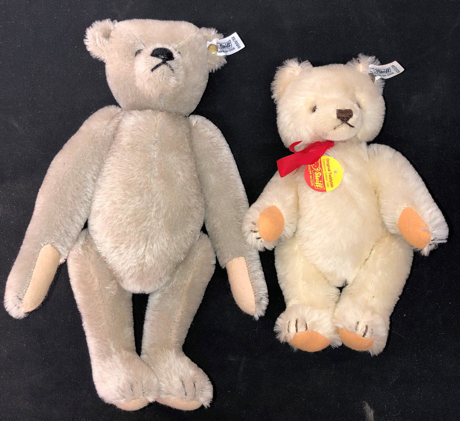 STEIFF BEARS (2): Ear button with white and black tag; (1) grey bear; H- 12"; (1) white bear with chest tag (1982) and cleaning tips tag; normal wear; G-VG
