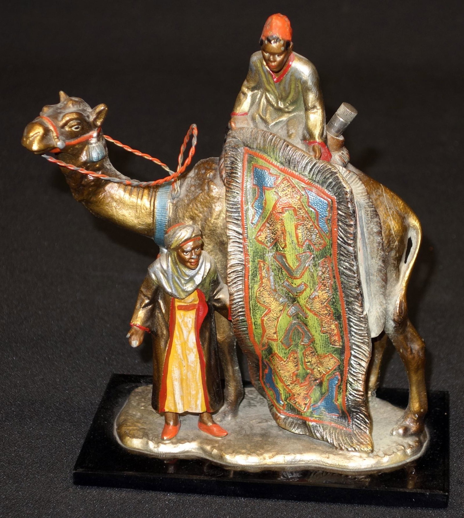 FIGURAL ARAB STICK LIGHTER: Painted metal of carpet seller with camel and lighting stick. Minor paint chips. H7.5" VG-EX