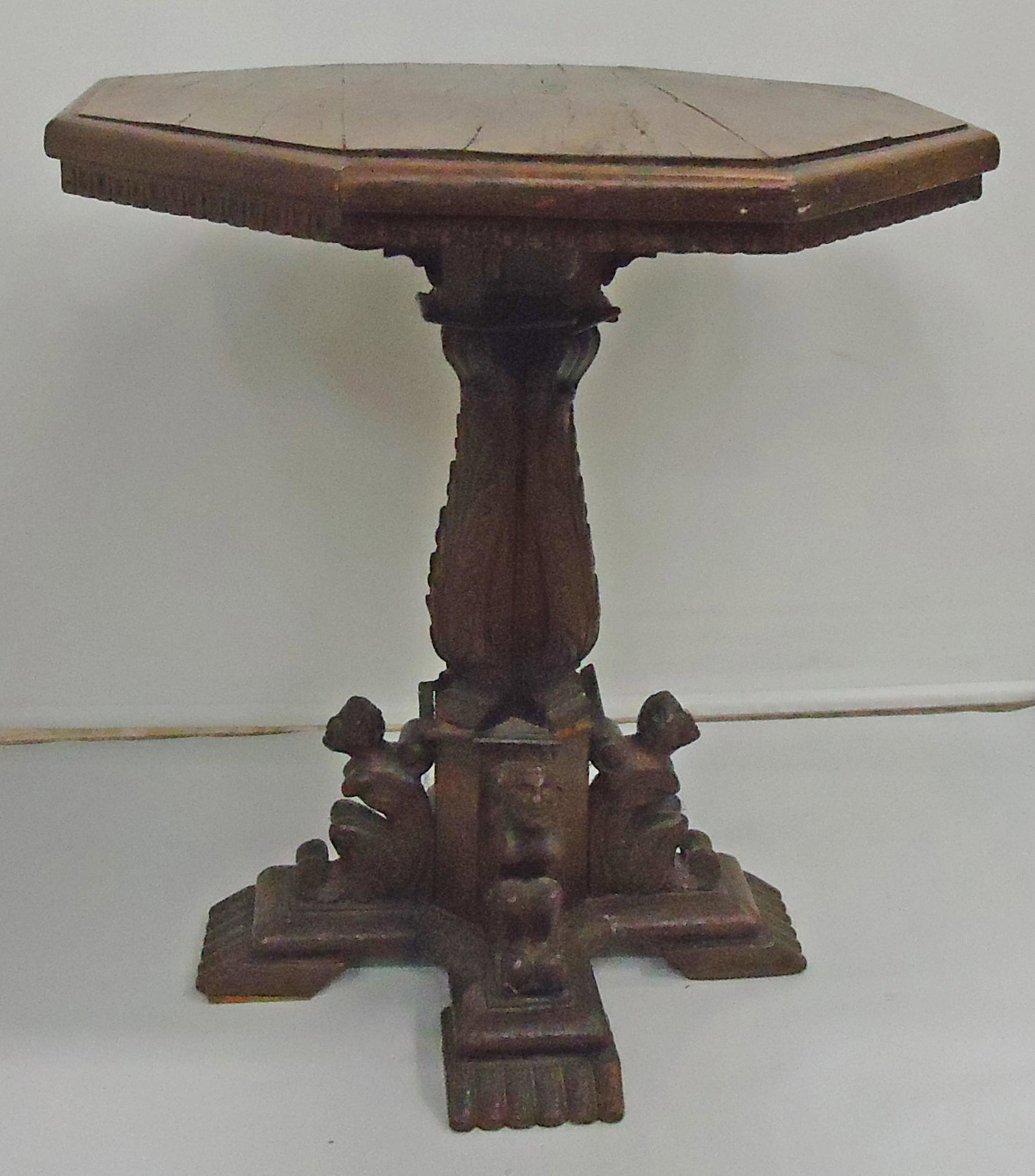 EARLY CONTINENTAL TABLE: Walnut and mixed wood; octagonal top; carved pedestal; (4) figural foot braces; top patched; wear; H-26", Dia.-23", F-G