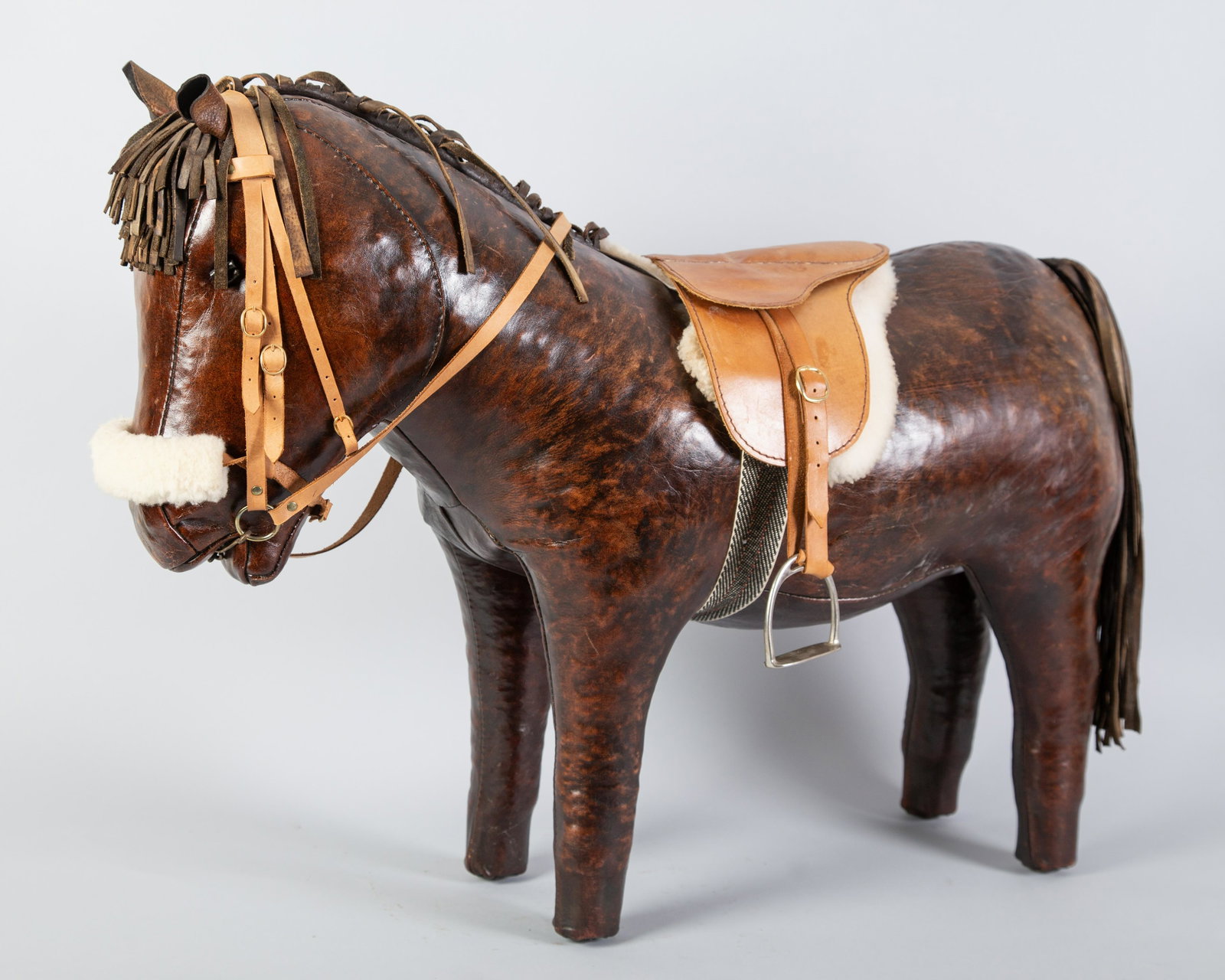 CHILDS LEATHER PONY/FOOT STOOL: Stitched leather with fringe mane & tail. Bridal, saddle & pad added. H26" L34" Normal wear. G-VG
