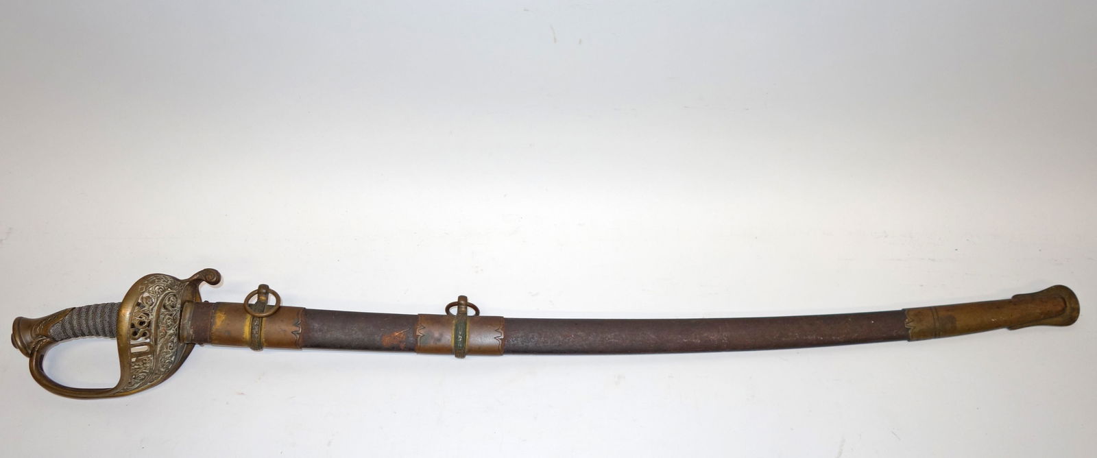 CIVIL WAR U.S. SWORD - PROVENANCE: Openwork brass guard with "U.S."; blade engraved but rust; metal scabbard; wear and rust; L-38", F-G PROVENANCE: Belonged to Cyrus Butler a Union Army officer from Pennsylvania, who was shot to death