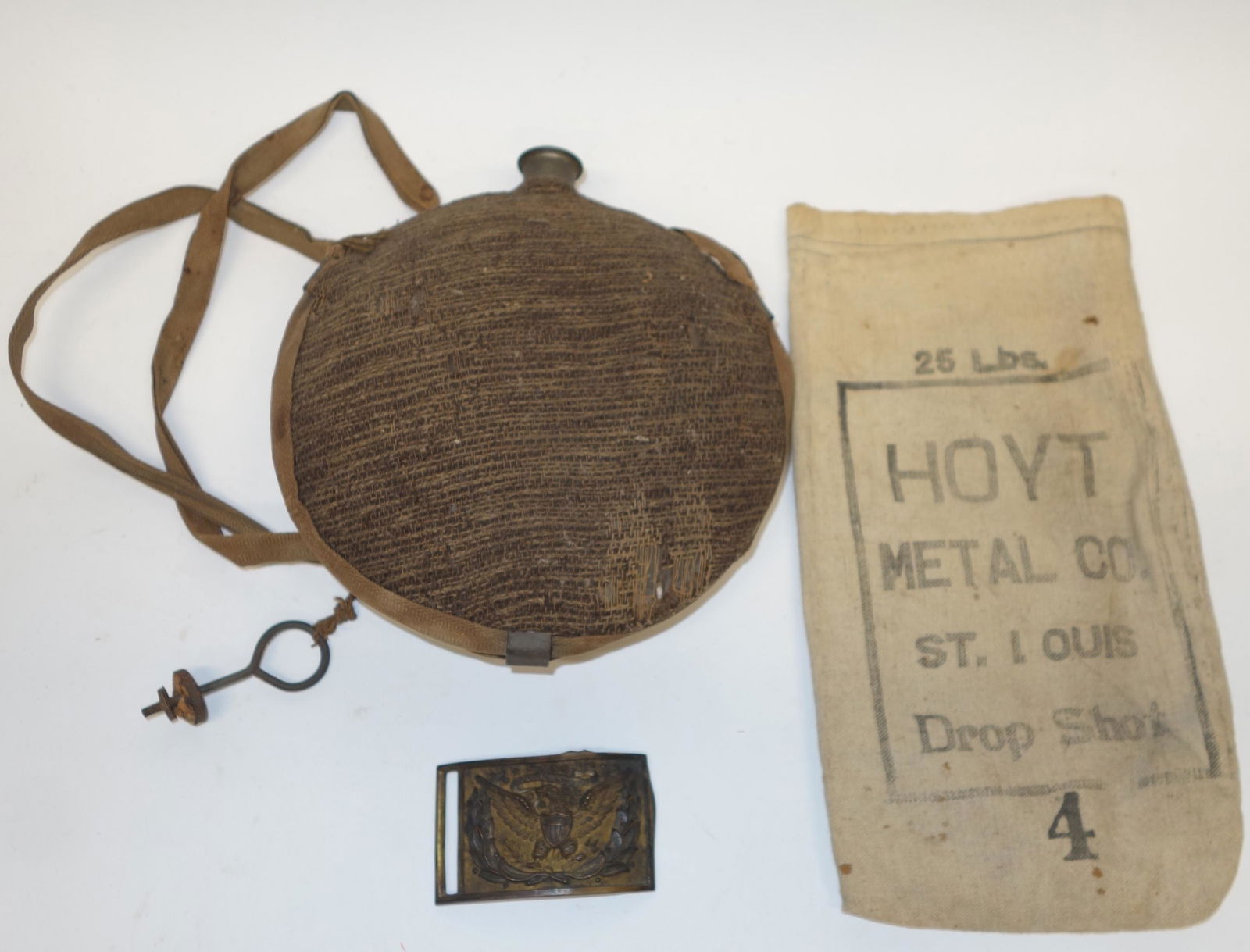 CIVIL WAR U.S. BUCKLE, CANTEEN, ETC. - PROVENANCE: (1) brass buckle with eagle, bent; (1) tin canteen, cloth covered, no stopper; (1) shot bag; wear; canteen H-8 1/2", F-GPROVENANCE: Belonged to Cyrus Butler a Union Army officer from Pennsylvania who