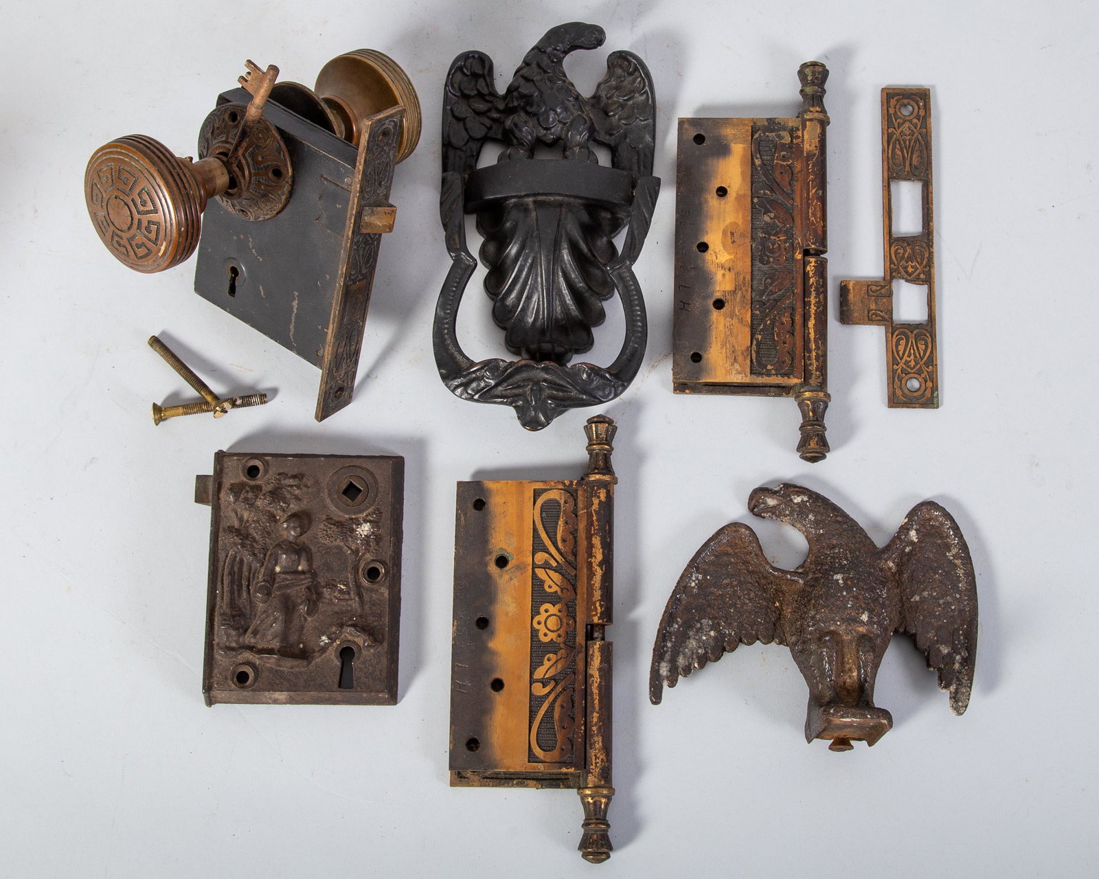 ANTIQUE HARDWARE (5): Cast iron; cast metal; (1) snowbird; H- 5"; (1) figural doorlock; "Wallace Lock"; 1858; woman in forest; lock only; (1) Victorian lock and knobs; has wallplate and key; key not tested; (1) pair of orn