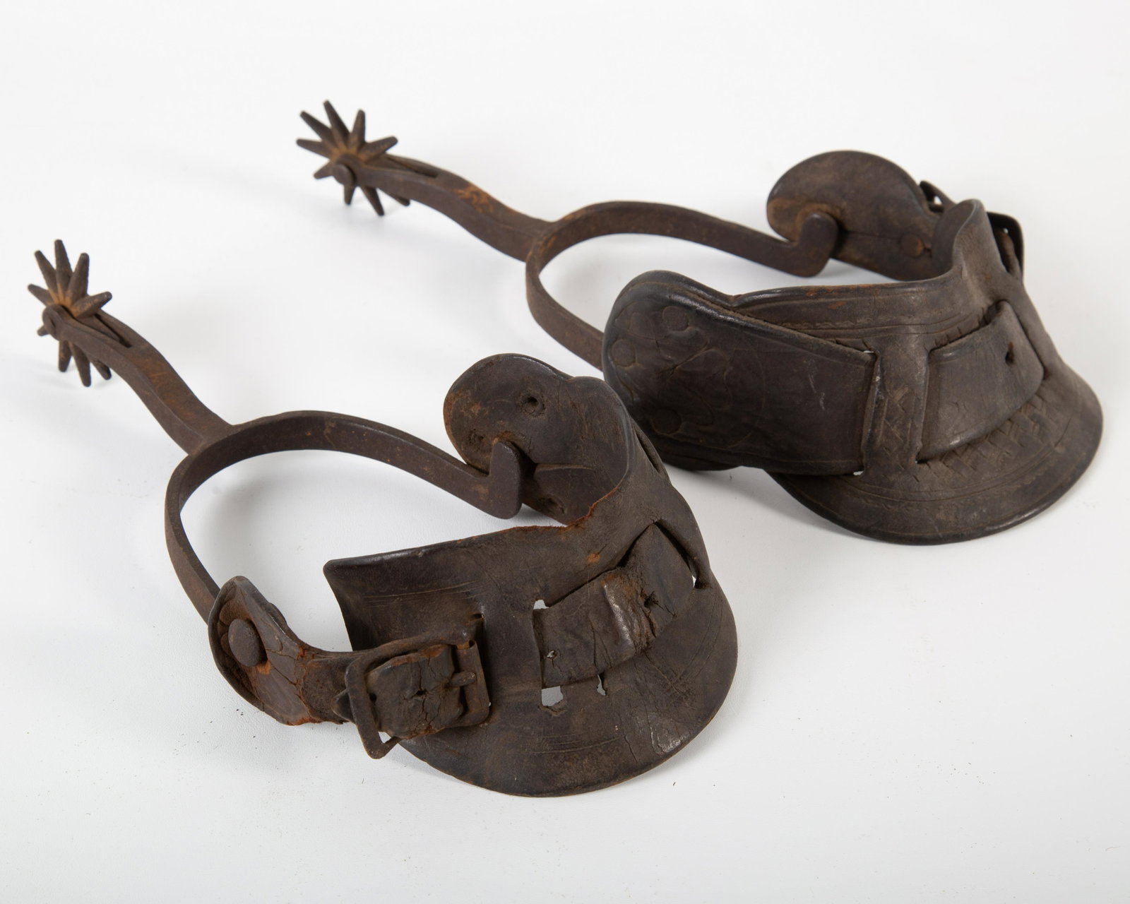 PAIR ON ANTIQUE SPURS: Wroght iron and leather; worn; L- 10"; F-G