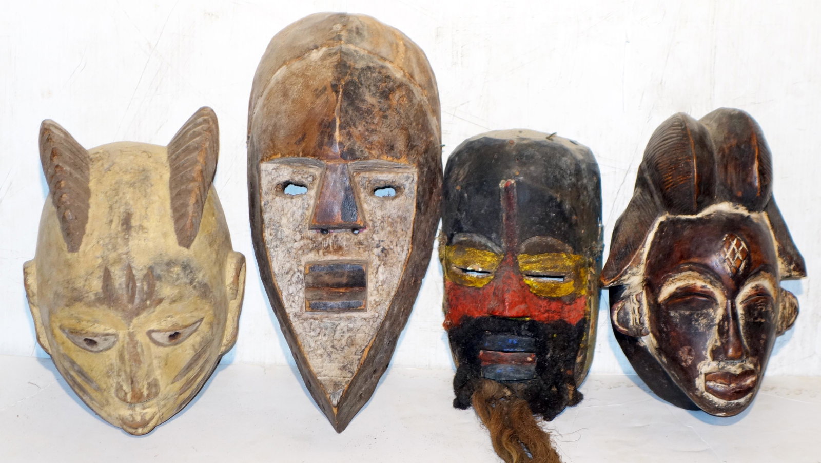 TRIBAL ART CARVED, PAINTED MASKS (4): (1) with raffia; (1) Nepalese Shaman's mask; wear; F-G