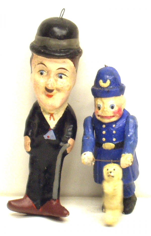 (2) FIGURAL CHARACTER ORNAMENTS: (2) FIGURAL CHARACTER ORNAMENTS - Painted composition, (1) Charlie Chaplin, (1) policeman with dog; minor seam separation on Charlie near neck; minor paint loss; scuffs and blemishes; H-4"-5", G-VG