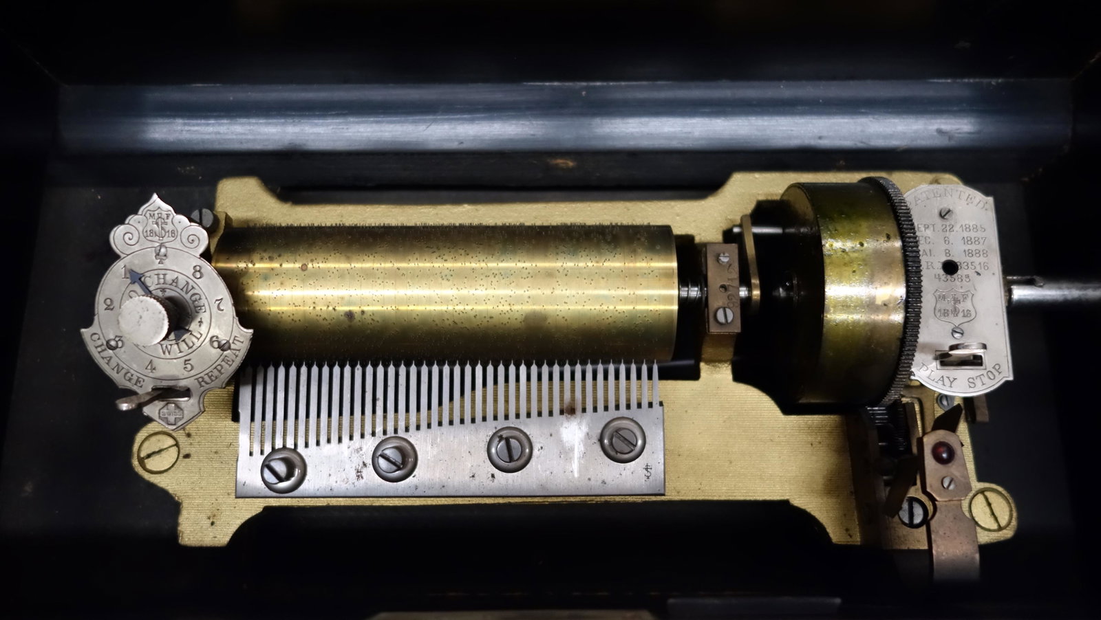CYLINDER MUSIC BOX: Swiss M.F.; (10) airs; 6" cylinder; single comb; outside crank; teeth intact; plays; wood grain painted box; slight inlay loss; L- 16" (box); G-VG