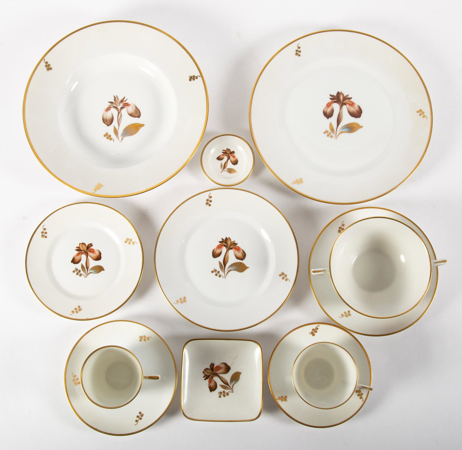 ROYAL COPENHAGEN TABLEWARE: Large service; "Brown Iris"; (14) double handled cups and saucers; (12) coffee cups and saucers; (21) after dinner cups and saucers; (7) butter pats; (2) bone dishes (?); (19) bread and butter plates;