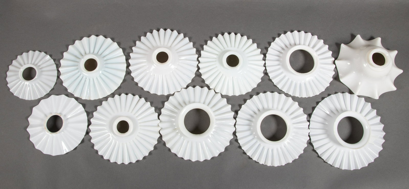 11 Saucer Form Ruffled Rim Opaque Glass Industrial Light Shades: Collection of 11 Ruffled Rim Saucer Form Industrial Milk Glass Shades of various sizes. Most approximately 8" in diameter. The smallest, almost paper thin and very delicate, is 5 1/2" in diameter. All