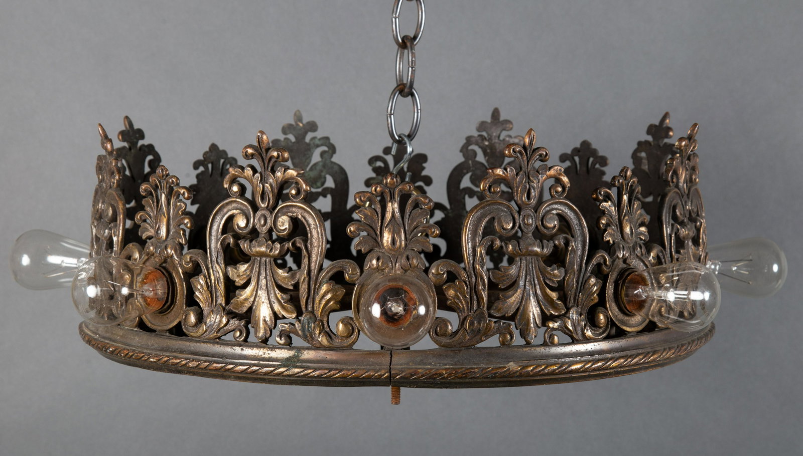 Bronze Filigree Cylindrical Theater Chandelier: An eight socket bronze theater light of Romantic Revival / Mediteranean form. Patinated bronzefiligree castings. 6" high with a diameter 18" excluding light bulbs. CONDITION: Most likely part of a lar