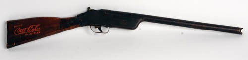 1930'S "COCA-COLA IN BOTTLES" TOY RIFLE: 1930's "Coca-Cola In Bottles" toy rifle Shoots rubber bands 25" long metal with wood handle. Coca-Cola In Bottle on both sides of wood. Both logos are strong. A very neat and unusual piece. Has been p
