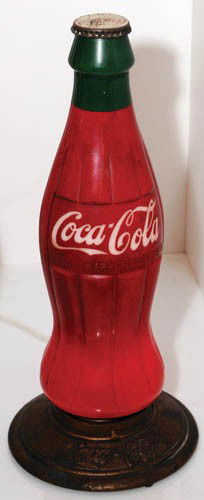 LATE 1920'S 20" COCA-COLA BOTTLE LAMP: Late 1920's 20" bottle lamp Glass with original cap and embossed metal base. Lights up and displays just beautifully. Scratching on cap, wear and pitting on base. A beautiful example