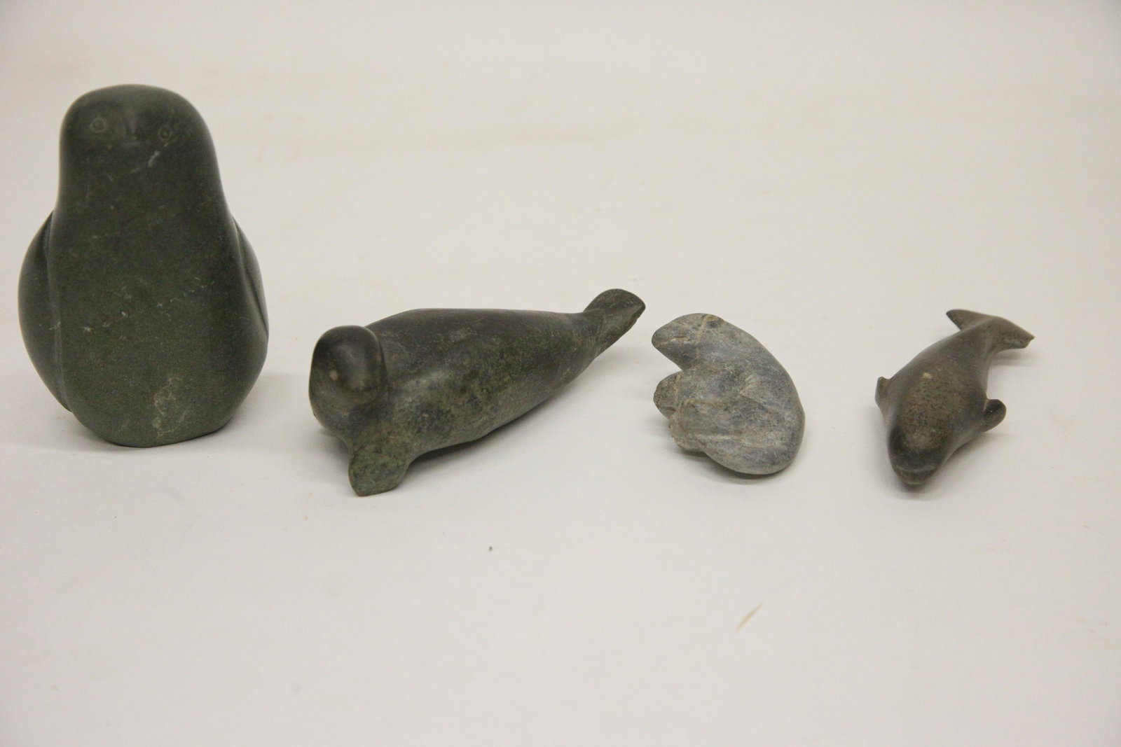 (4) SOAPSTONE ANIMALS: (1) seal; L- 6"; (1) dolphin; signed; chip on tail; L- 5"; (1) bear; L- 3 1/4"; (1) owl; L- 6"; normal wear; G
