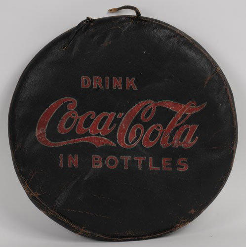 1920'S TO 30'S COCA-COLA SEAT CUSHION: 15" diameter, 2" thick; very rare, possibly unique; you could be the only Coca-Cola collector to own your very own vintage "Tush Cush"; still has its original carry strap (although it is broken); cons