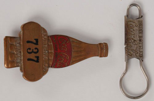 COCA-COLA KEY RING & INDIANAPOLIS BOTTLING COMPANY: 1908 and circa 1930, respectively; key ring is 2" long, badge is 2 1/2" tall; some medium plating wear on the key ring and its missing its chain on the left side; the badge has nice enameling remainin