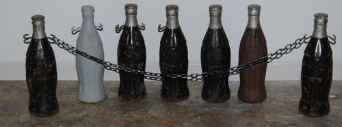 7 COCA-COLA CAST IRON BOTTLE COLUMN TOPPERS: Circa 1930's; each bottle is a 20" tall cast iron Christmas bottle; and each bottle is quite heavy, weighing approximately 30 to 40 pounds; these bottles have receivers underneath each piece which is