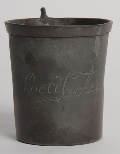 PRE-1900 COCA-COLA PEWTER GLASS HOLDER: 2 3/4" tall with its original decorative handle; the museum believes the engraved Coca-Cola logo to be period-correct however does not warrant the engraving to have happened pre-1900; the matching pat