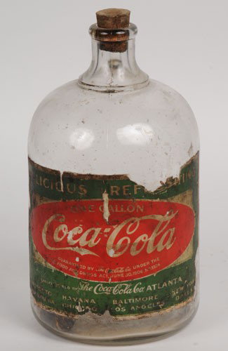 CIRCA 1915 COCA-COLA JUG with PAPER LABEL: Nice one gallon glass jug with a label that remains over 90% intact, some edge chips and nicks; as well as a few interior small paper chips with medium wear, marks and medium to heavy soiling; conditi