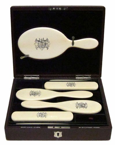 ASPREY BOXED IVORY BRUSH SET: Tooled leather case contains (2) combs, (4) brushes, (1) mirror; case also has compartments with covers; case and contents monogrammed "H.M.C."; minor wear; L-11 1/2", EX-NM