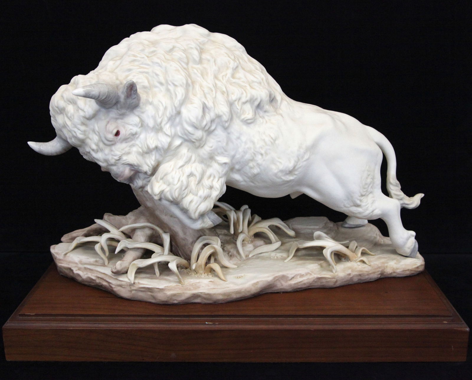 CYBIS BUFFALO: Painted ceramic, rests on walnut base; normal wear; H-11", L-18", VG-EX
