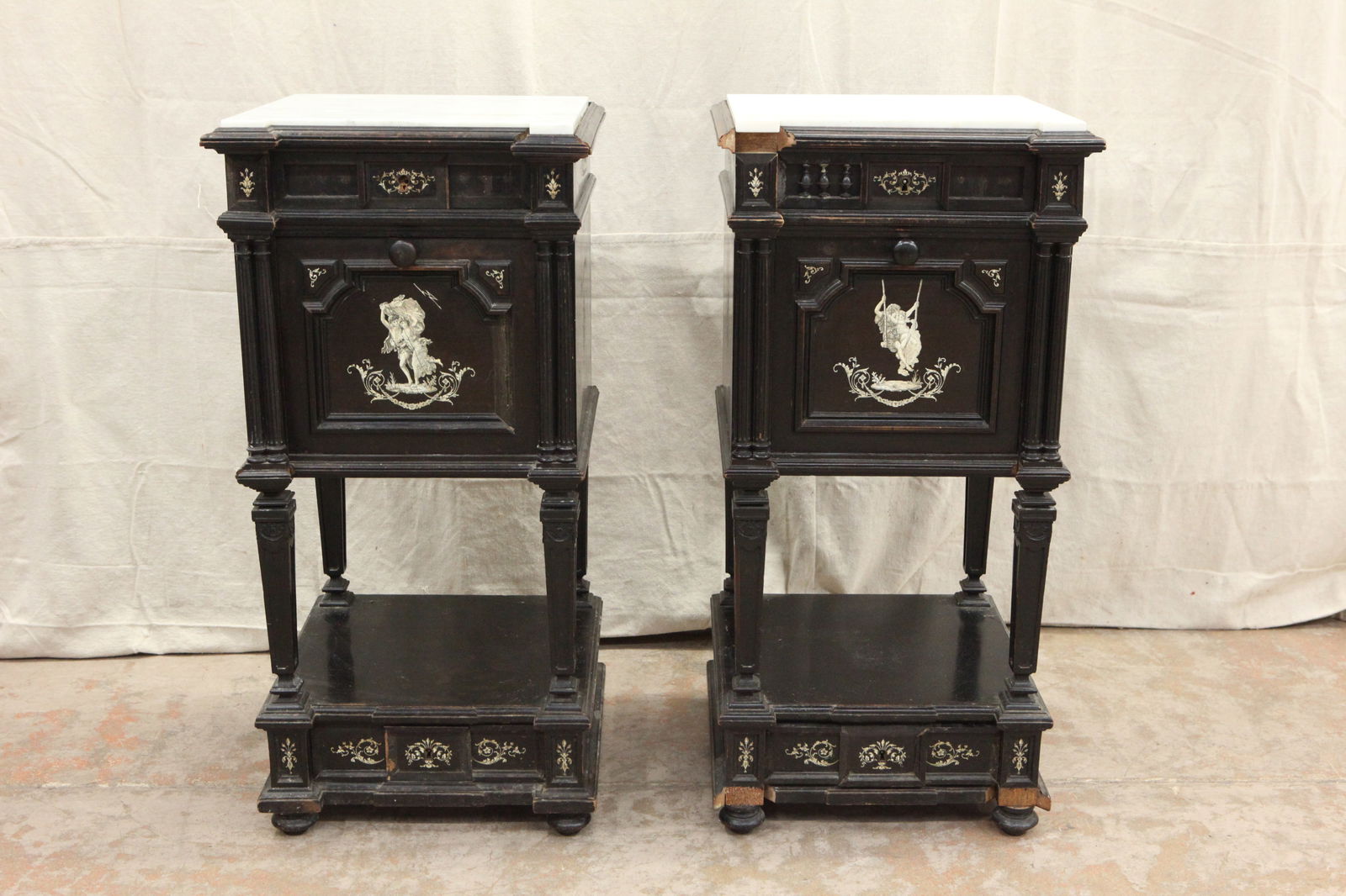 EBONIZED END CABINETS: Pair wood ebonized cabinets with marble tops; classical inlay scenes; drop doors with marble tile compartment; two drawers, a lot of trim is off but present; some trim possibly missing; H-32", L-16",
