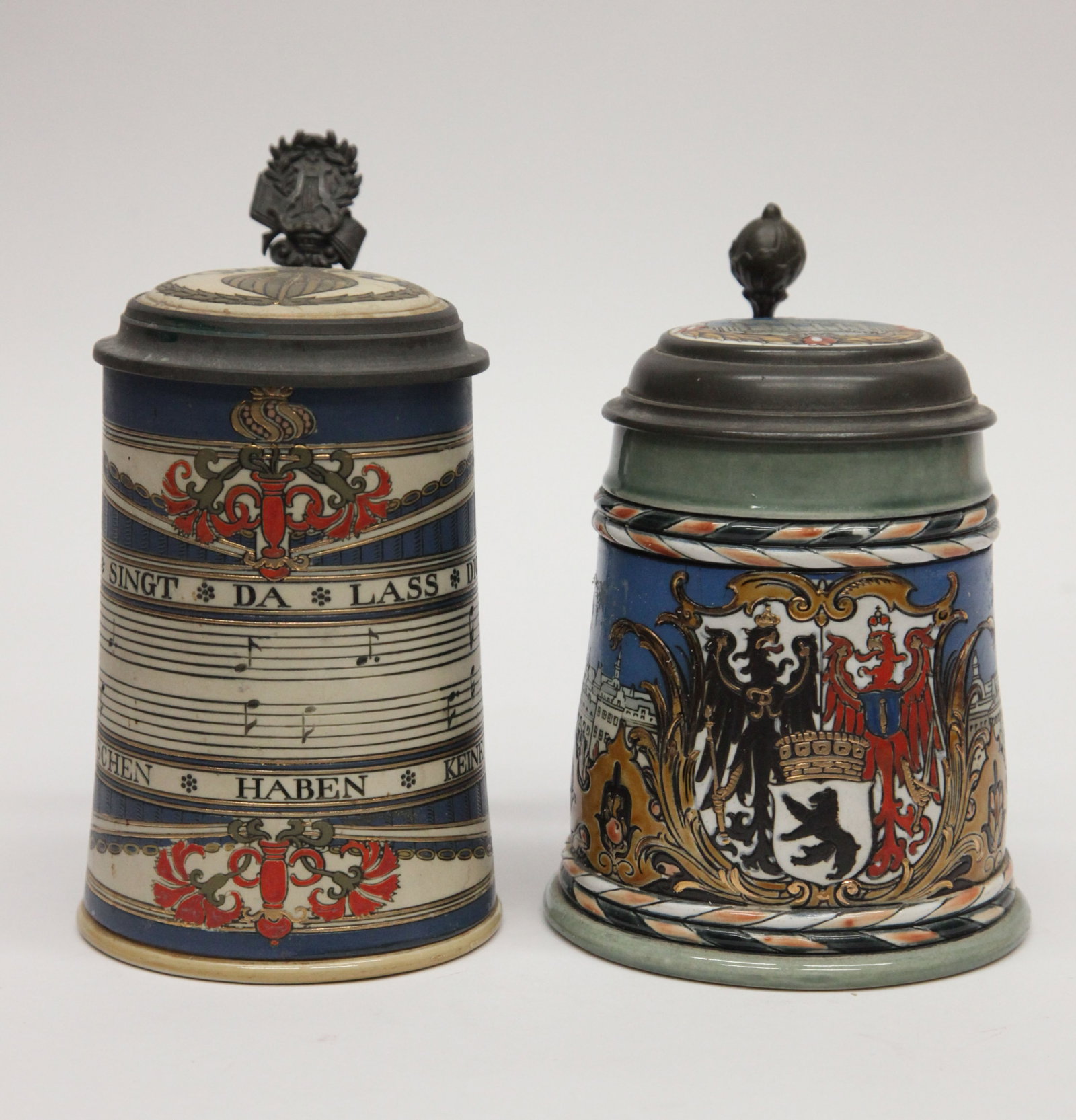 (2) METTLACH STEINS: Both have inset stoneware lids; (1) 2024 Berlin shield with city views, 1/2L, H-7"; (1) 2097 bars of music; 1/2L, H-7 1/2", normal wear; G-VG
