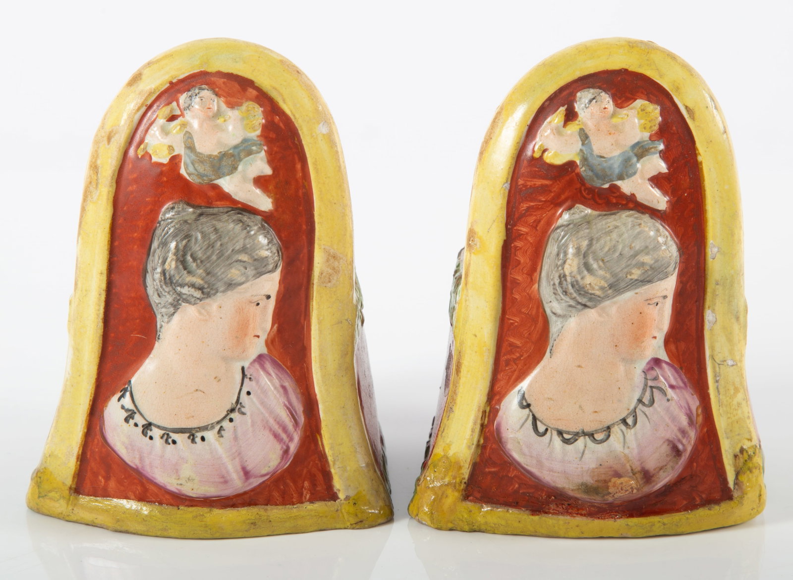 STAFFORDSHIRE WINDOW STOPS: Pair; painted ceramic; relief busts and foliate decoration; (2) small chips and minor touch up; H- 4 1/4"; G-G+