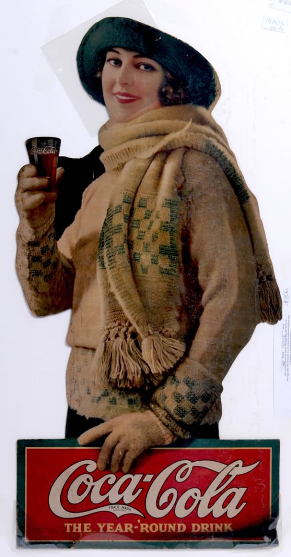 1923 COCA-COLA CARDBOARD CUT-OUT SIGN: 32" x 16". Slightly darkened with overall medium to heavier soiling, especially on the bottom sign area. The top of her hat has been slightly trimmed, otherwise minor marks and light to medium overall