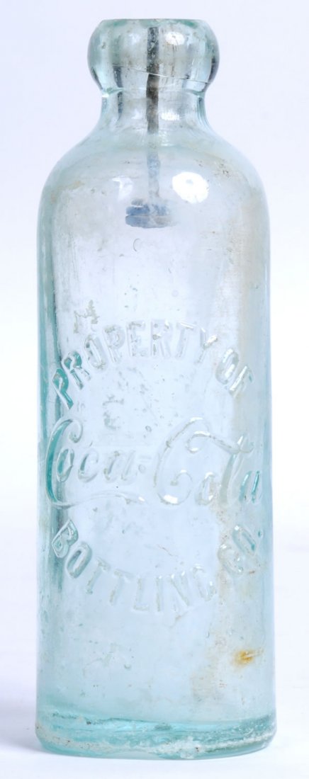 COCA-COLA BOTTLING CO. HUTCHINSON BOTTLE: Retains wire stopper. Small nicks and chip at the top of bottle and a large base chip with surface wear and heavy base perimeter abrasions. Partly clouded. Condition 5 to 6 / Fair