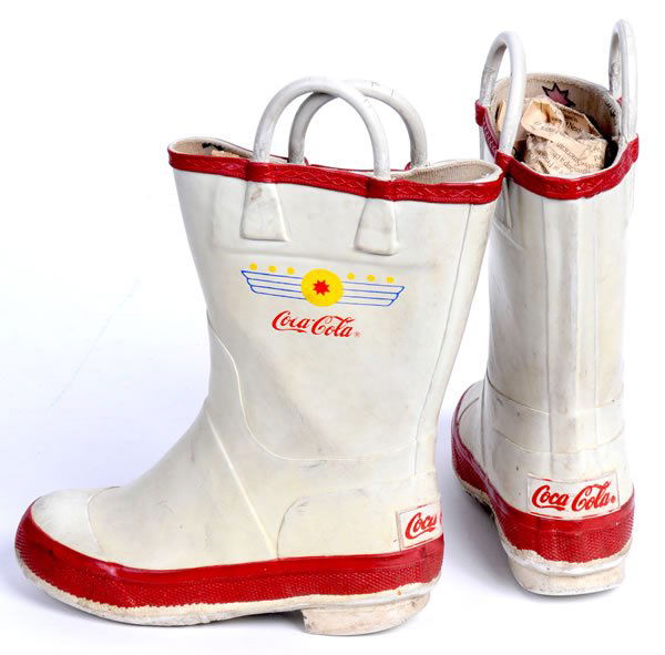 COCA-COLA CHILDREN'S RUBBER BOOTS: 9" tall. Circa 1950's to 1960's. Nice pair of slightly smaller boots in white and red with logo appearing at the top of both sides of the boot as well as the back of the heel. Canvas lined with genera