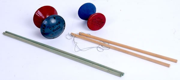 2 1930S COCA-COLA TOP GAMES: Sticks measure 12" to 16" long. One top is wooden, the other metal, and both are marked Coca-Cola. Only light wear. Condition 9 to 9.5 / NM