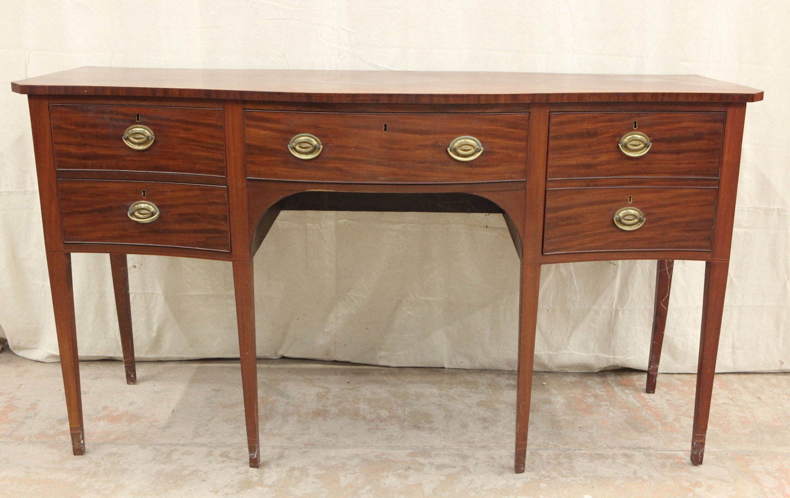 HEPPLEWHITE SIDEBOARD: Mahogany; serpentine front; line inlay top edge; (6) square tapered legs; (1) single drawer flanked by two drawers and a cellarette drawer; normal wear; H-39", L-72", G-VG