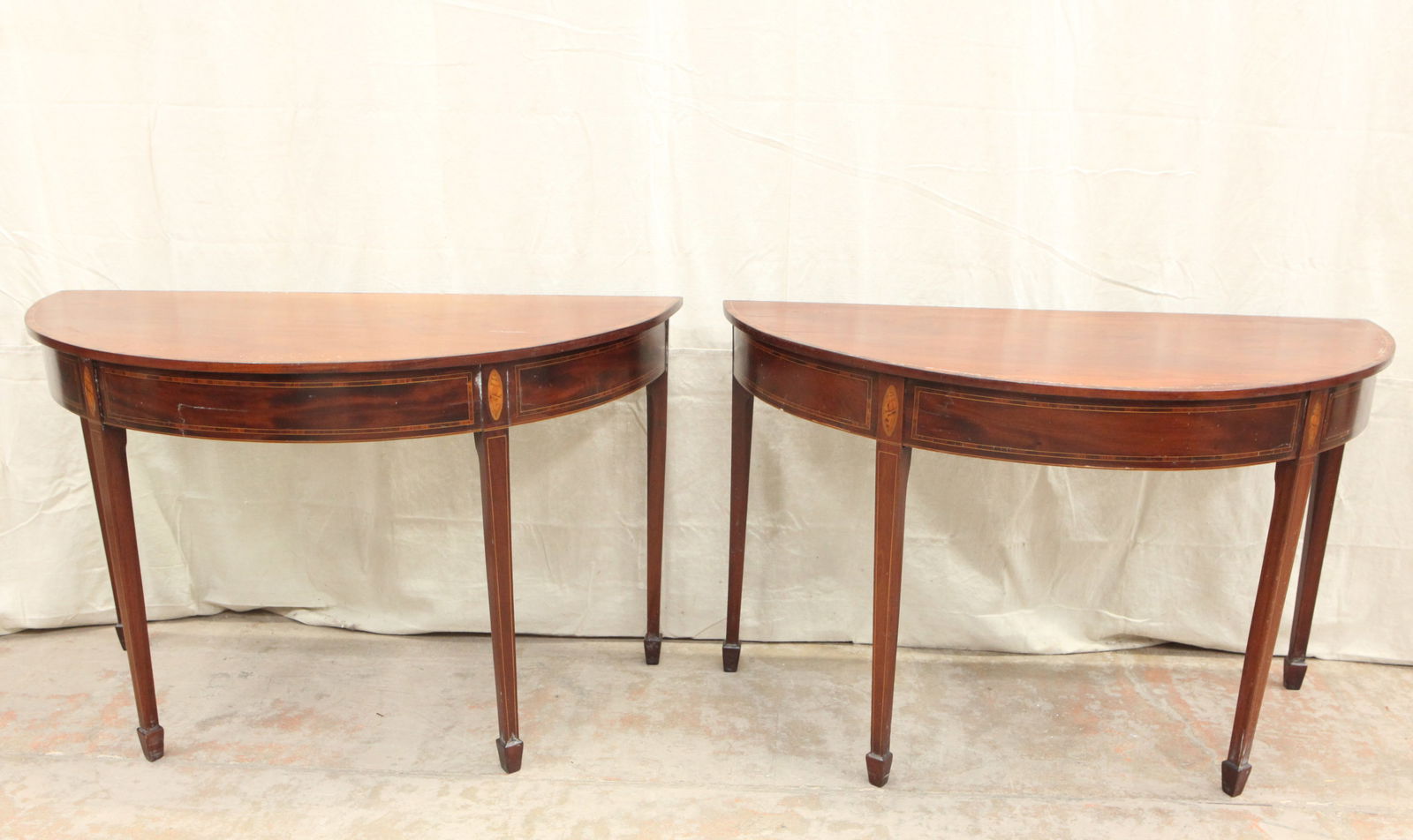 BANQUET END TABLES: Pair Hepplewhite style demi-lune tables; mahogany; band and shell inlay; spade feet; normal wear; H-28", L-44", depth 21" each; G